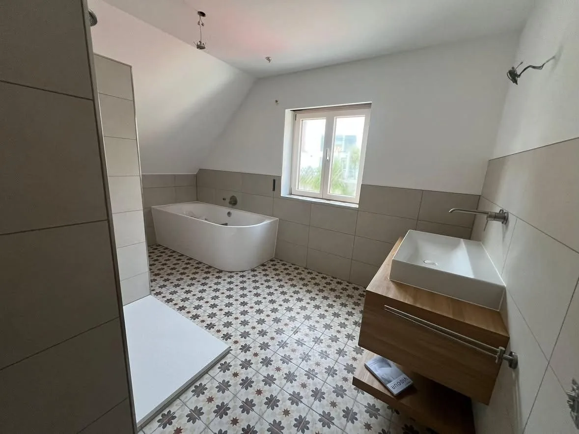 Dachbad mit Muster-Mosaikboden und Eckbadewanne