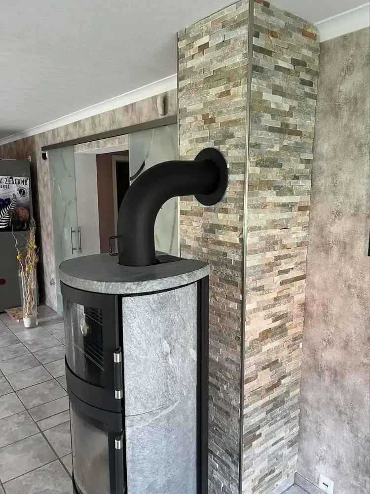 Naturstein-Wandverkleidung in Stapeloptik am Kaminofen